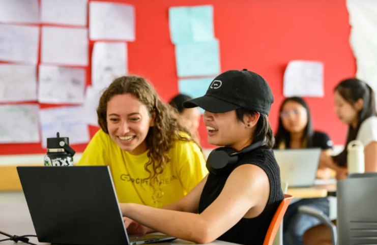 Estudiantes en clase de inglés con portátil