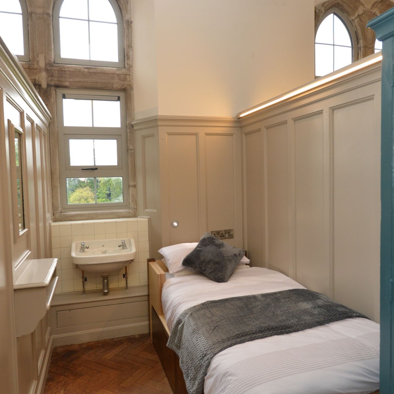 Habitación individual con ventana en arco y lavabo